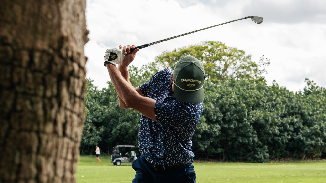 man swinging golf club in swingwear apparel