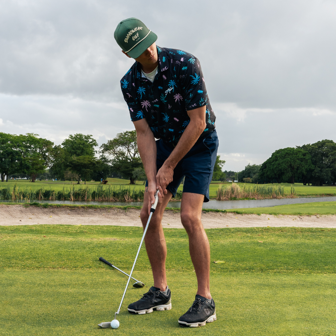 man playing golf in tropical golf polo